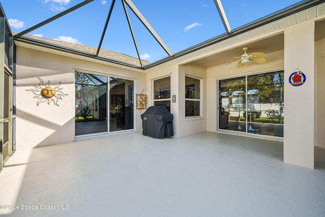 view of patio / terrace with a grill, ceiling fan, and glass enclosure