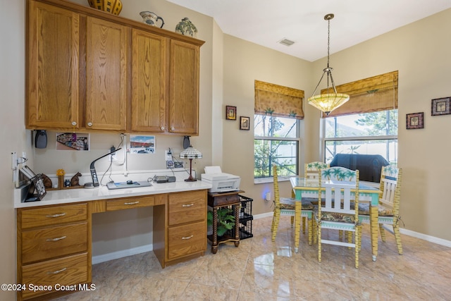 kitchen featuring built in desk and hanging light fixtures