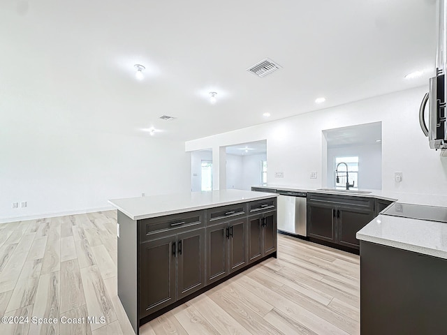 kitchen with sink, kitchen peninsula, stainless steel appliances, and light wood-type flooring