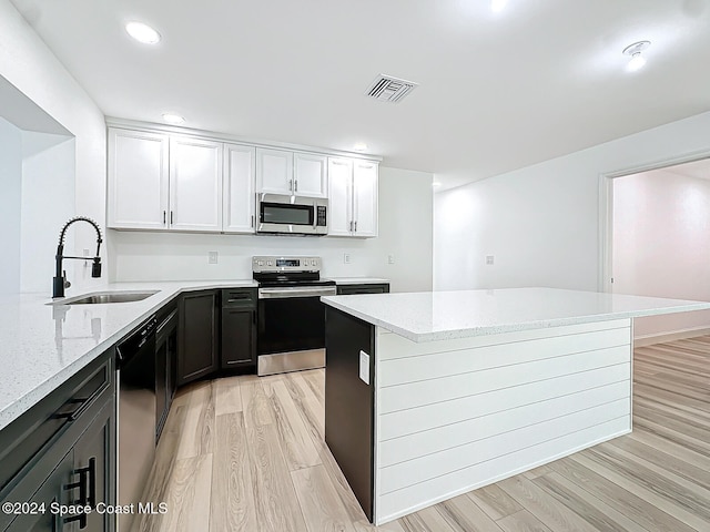 kitchen featuring light stone countertops, appliances with stainless steel finishes, sink, and white cabinets