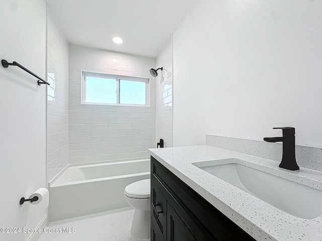 full bathroom featuring vanity, tiled shower / bath combo, and toilet