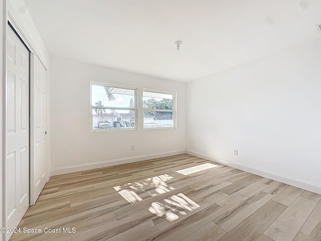 unfurnished bedroom with a closet and light hardwood / wood-style floors