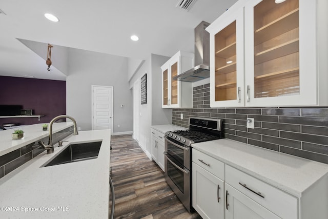 kitchen featuring dark hardwood / wood-style floors, wall chimney exhaust hood, stainless steel range, sink, and white cabinets