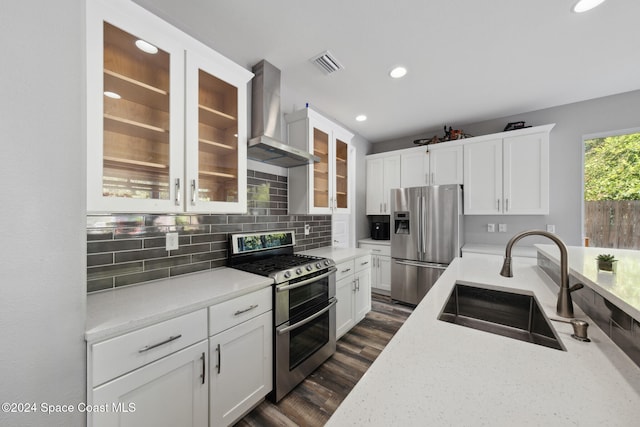 kitchen featuring decorative backsplash, wall chimney range hood, sink, appliances with stainless steel finishes, and dark hardwood / wood-style flooring