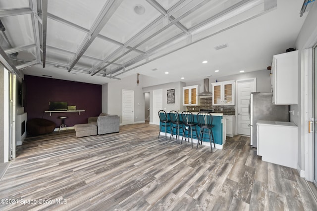 living room featuring coffered ceiling and light hardwood / wood-style flooring