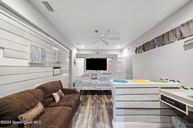 living room featuring ceiling fan and dark hardwood / wood-style flooring