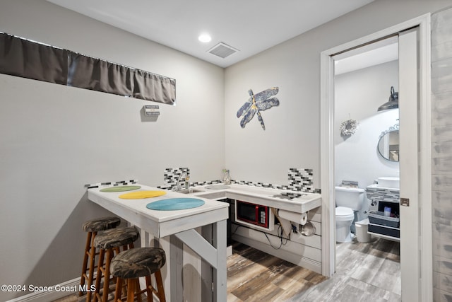 bathroom featuring wood-type flooring and toilet