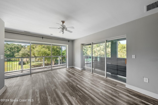 spare room featuring hardwood / wood-style flooring, a healthy amount of sunlight, and ceiling fan