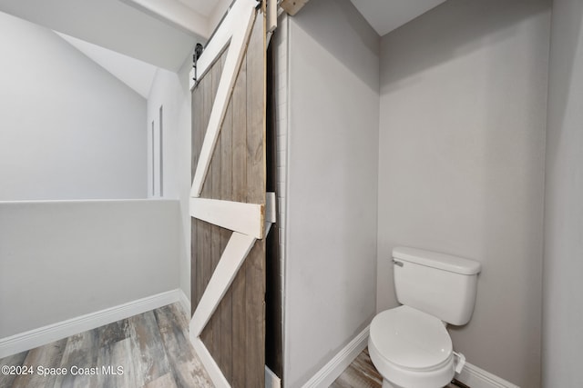 bathroom featuring toilet and wood-type flooring