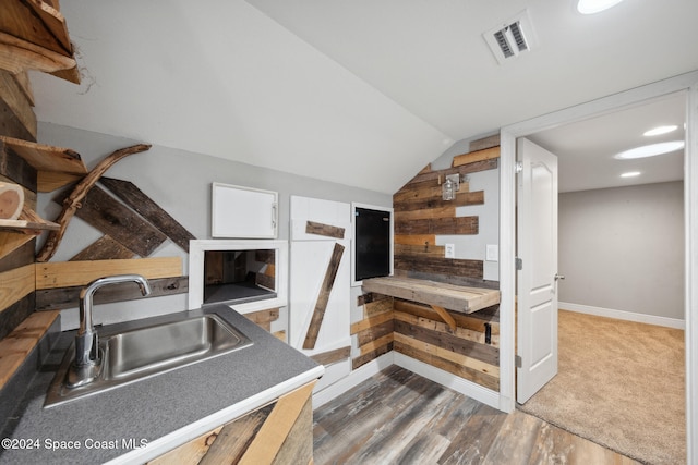 kitchen featuring vaulted ceiling, sink, and dark hardwood / wood-style floors