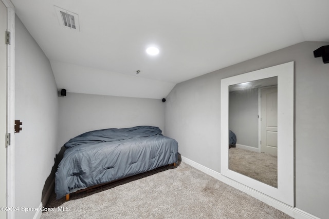 carpeted bedroom with lofted ceiling