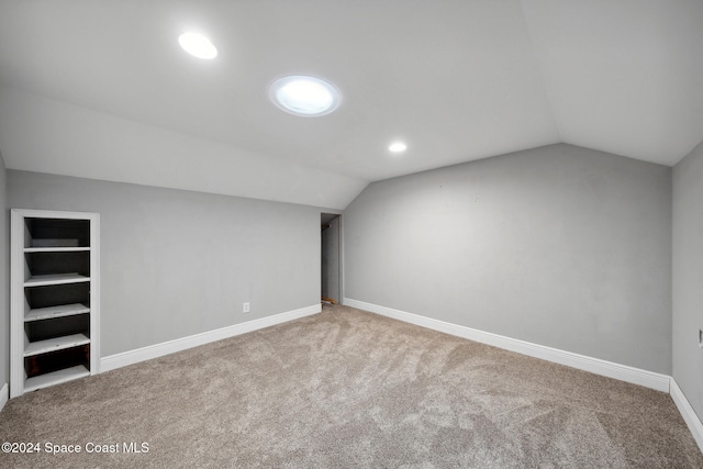 additional living space featuring carpet flooring and vaulted ceiling