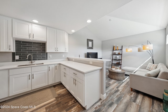 kitchen featuring white cabinets, sink, and vaulted ceiling