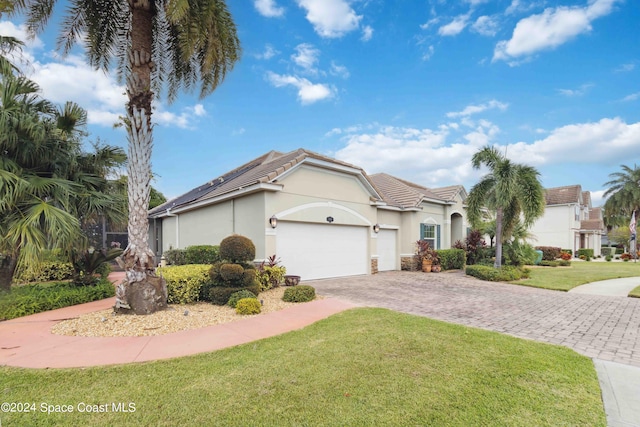 view of front of property with a garage and a front lawn