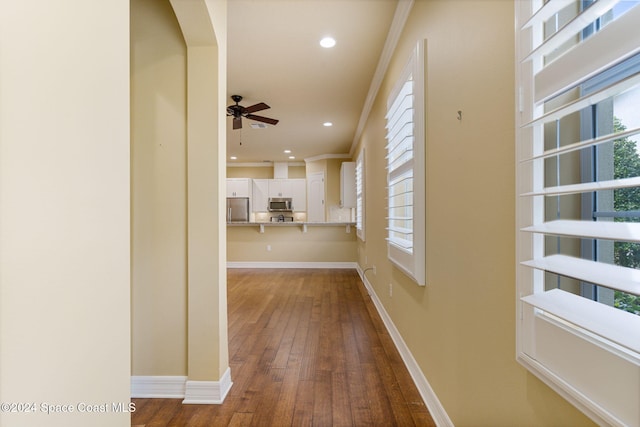 hallway featuring hardwood / wood-style floors and crown molding