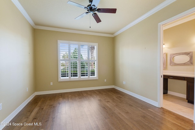 spare room with ornamental molding, light wood-type flooring, ceiling fan, and built in desk