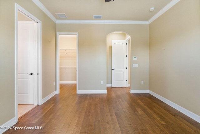 spare room with dark wood-type flooring and crown molding