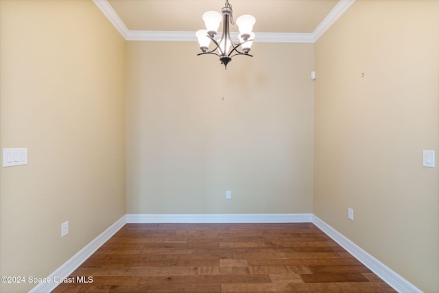 spare room with crown molding, an inviting chandelier, and dark hardwood / wood-style flooring