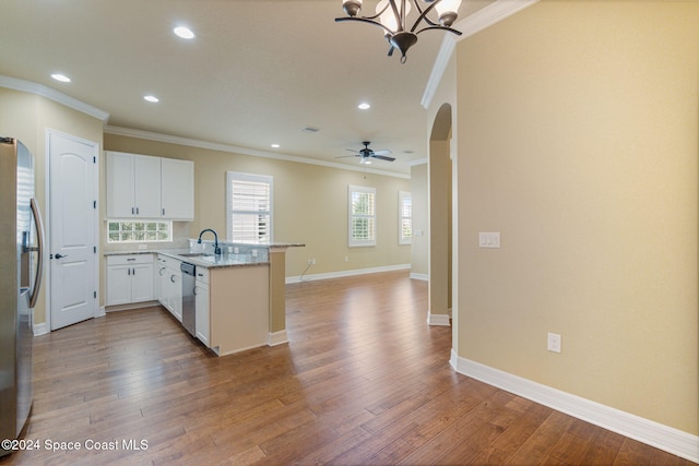 kitchen with white cabinetry, appliances with stainless steel finishes, kitchen peninsula, hardwood / wood-style floors, and crown molding