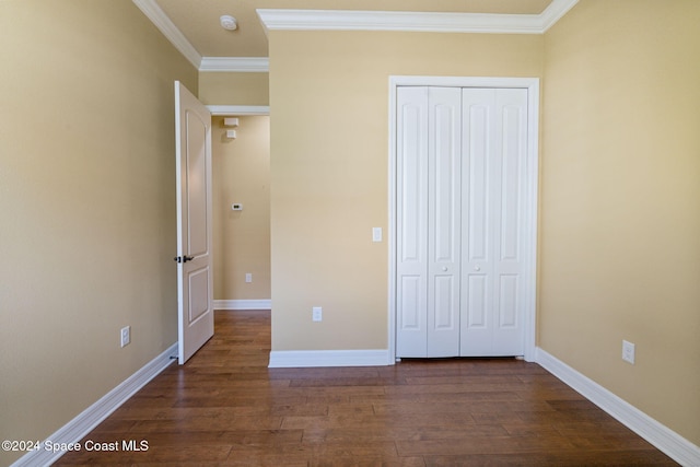 unfurnished bedroom with dark hardwood / wood-style floors, a closet, and ornamental molding