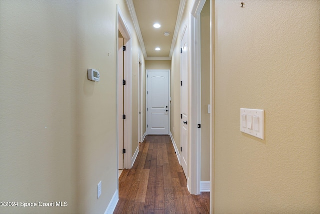 corridor with ornamental molding and hardwood / wood-style flooring