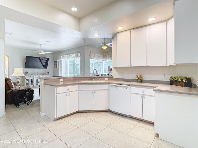 kitchen with dishwasher, kitchen peninsula, sink, light tile patterned floors, and white cabinetry