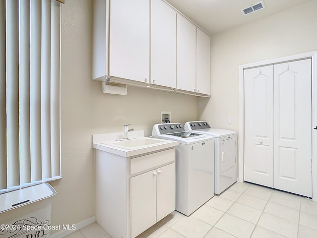 washroom with cabinets, sink, washer and clothes dryer, and light tile patterned floors