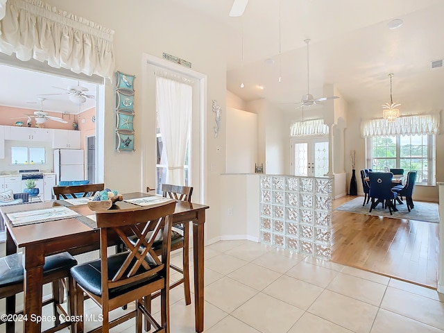 dining area featuring french doors, ceiling fan, light wood-type flooring, and vaulted ceiling