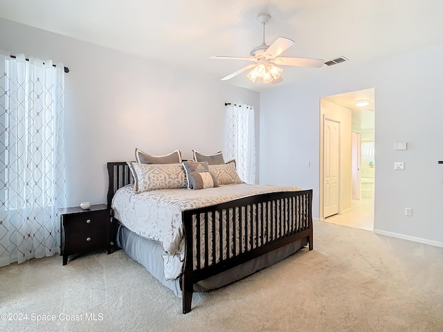 carpeted bedroom with connected bathroom and ceiling fan