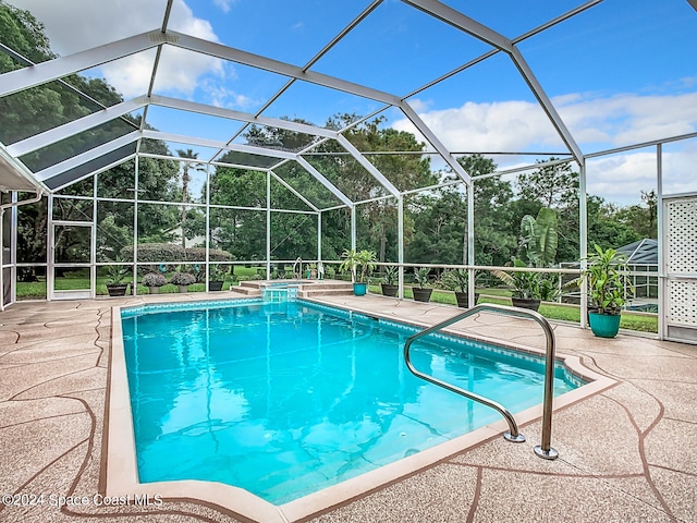 view of swimming pool featuring a patio area and a lanai