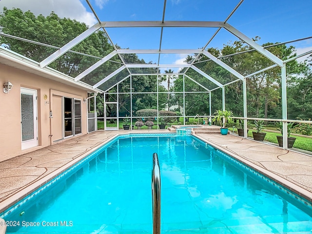 view of pool with a patio area and a lanai