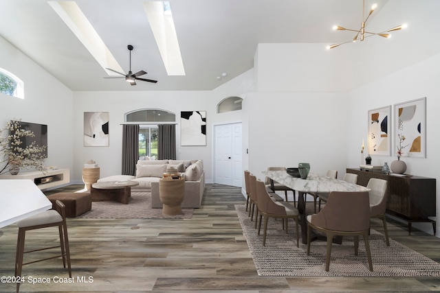 dining space featuring hardwood / wood-style flooring, ceiling fan with notable chandelier, and plenty of natural light