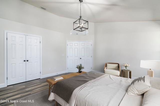 bedroom featuring lofted ceiling, a chandelier, dark hardwood / wood-style floors, and a closet