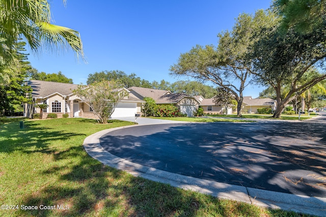 ranch-style house featuring a front lawn and a garage