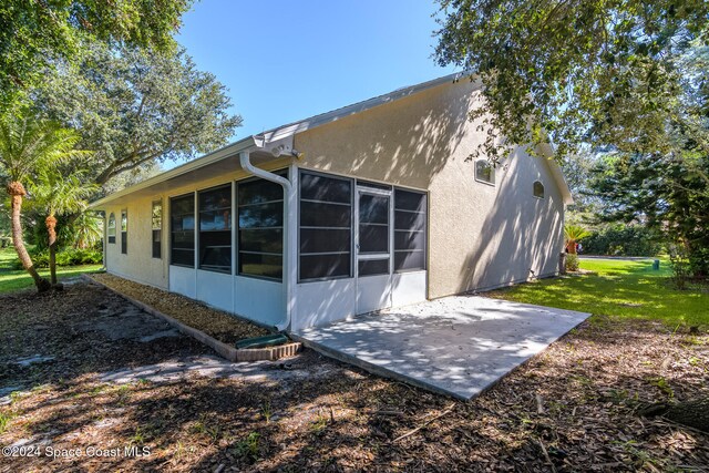 view of home's exterior with a yard and a patio area