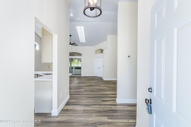 hallway featuring sink, dark wood-type flooring, and a skylight