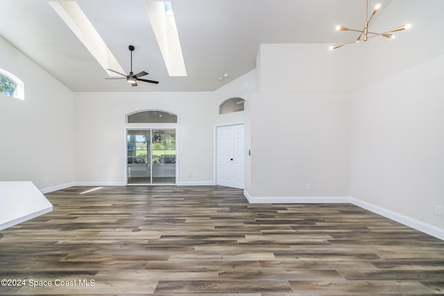 unfurnished living room with a skylight, plenty of natural light, and dark hardwood / wood-style floors