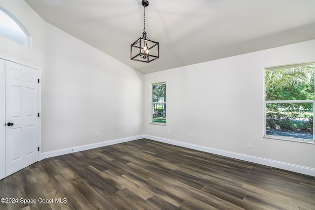 480 Prestwick Ct, Melbourne, FL 32940 - empty room with baseboards, dark wood finished floors, vaulted ceiling, and an inviting chandelier