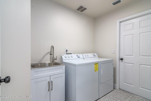 480 Prestwick Ct, Melbourne, FL 32940 - washroom with a sink, visible vents, cabinet space, and washing machine and clothes dryer