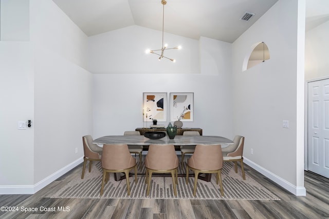 dining space featuring dark wood-type flooring, high vaulted ceiling, and a notable chandelier