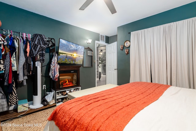 bedroom with ceiling fan, a fireplace, and hardwood / wood-style floors