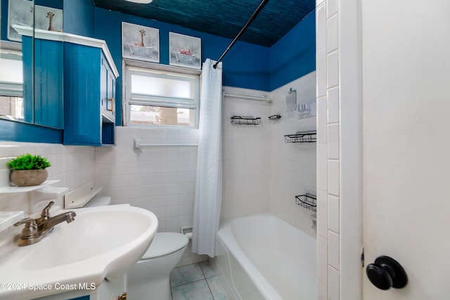 full bathroom with sink, tile walls, shower / bathtub combination with curtain, tile patterned flooring, and toilet