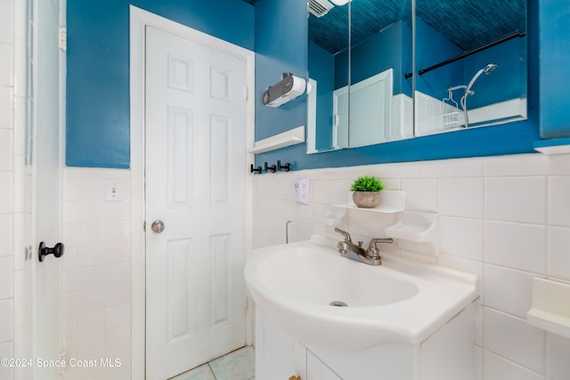 bathroom with vanity and tile walls