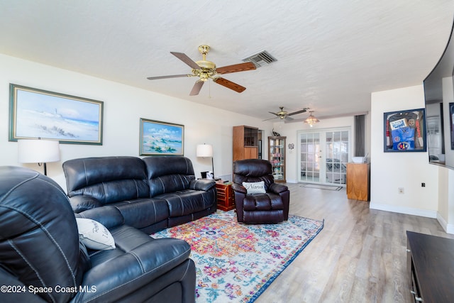 living room with ceiling fan, wood-type flooring, and a textured ceiling