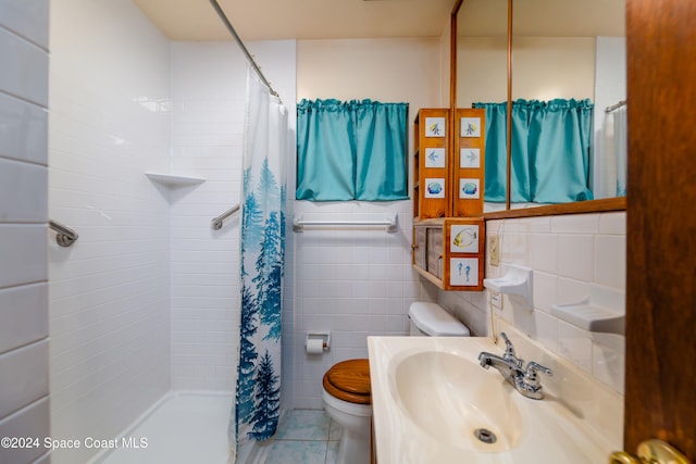 bathroom with sink, tile patterned flooring, toilet, tile walls, and curtained shower