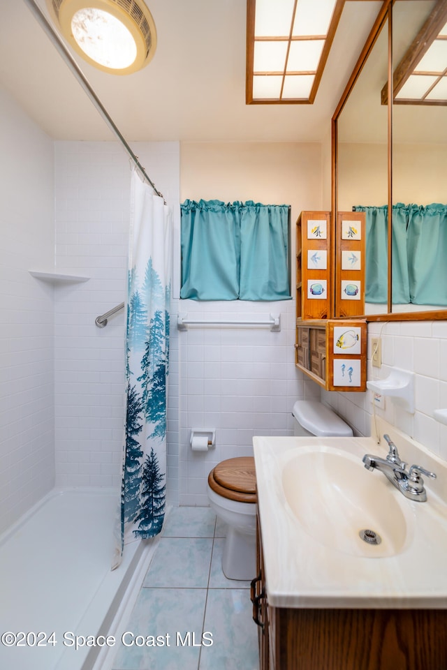 bathroom featuring vanity, tile patterned floors, toilet, tile walls, and walk in shower