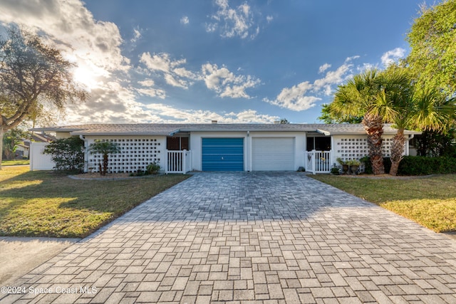 single story home featuring a front yard and a garage