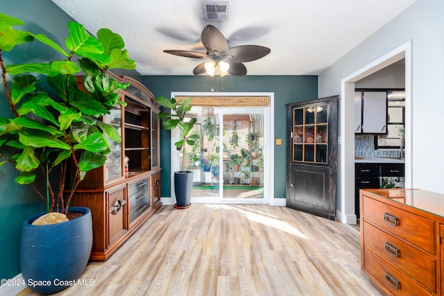 living room with light hardwood / wood-style flooring and ceiling fan