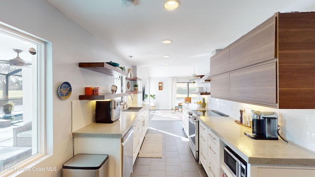 kitchen featuring appliances with stainless steel finishes, tasteful backsplash, light tile patterned floors, and plenty of natural light