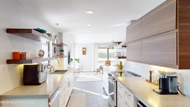 kitchen with white cabinetry, stainless steel appliances, sink, and decorative light fixtures